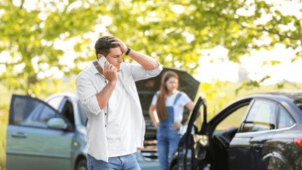 Man on phone with insurance after accident with another car<br />
